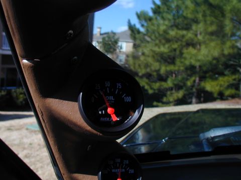 1988 Ford Bronco - Close-up of aftermarket oil and water temperature gauges installed on the A-pillar of a vehicle.