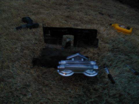 1988 Ford Bronco - A gauge cluster and some tools are laid out on the grass.