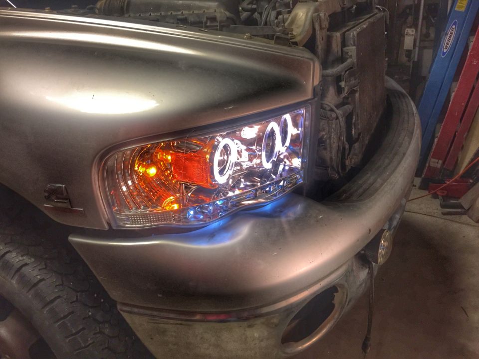 Silver truck front with custom halo headlights and blue accent lighting