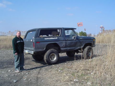 1979 Ford Bronco - 1978 Ford Bronco parked on a dirt path with dry grass. A man stands beside the vehicle.