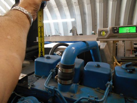 1992 Ford Bronco - A person is measuring a blue engine part with a tape measure, while a digital level is also visible.