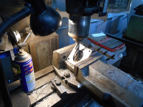 1992 Ford Bronco - Metal part being machined on a milling machine in a workshop setting.