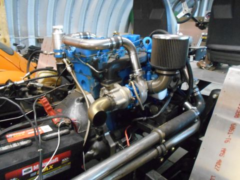 1992 Ford Bronco - Close-up of a turbocharged engine with a blue block and custom exhaust piping.