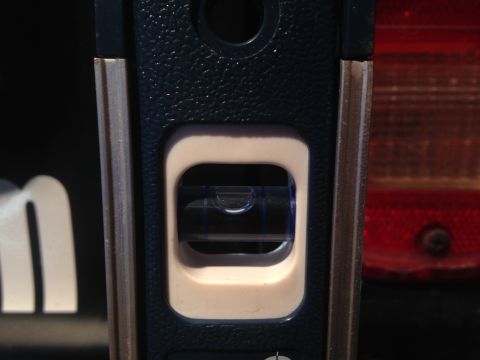 1979 Ford Bronco - A level tool is placed against the exterior of a vehicle, showing the bubble indicating a level surface.