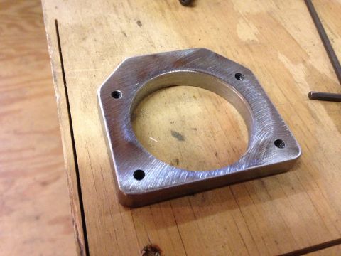 1979 Ford Bronco - Custom metal adapter plate shown on a workbench, likely for automotive modification.