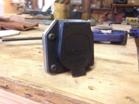 1979 Ford Bronco - A CURT trailer hitch connector is shown on a wooden surface, with tools in the background.