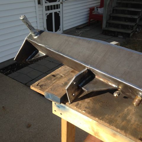 1979 Ford Bronco - A custom-fabricated metal bumper is shown on a workbench, with a house and stairs in the background.