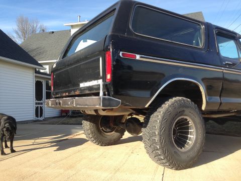 1979 Ford Bronco - Rear view of a black SUV with off-road tires and a fabricated bumper, parked in a driveway.