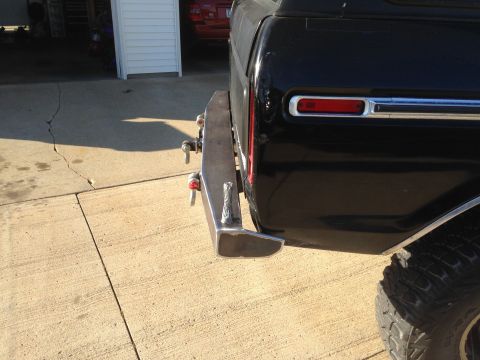 1979 Ford Bronco - A custom metal bumper is attached to the rear of a black SUV, obscuring the original bumper.