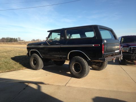 1979 Ford Bronco - This black 1979 Ford Bronco is shown from the rear, an aftermarket bumper and large tires.