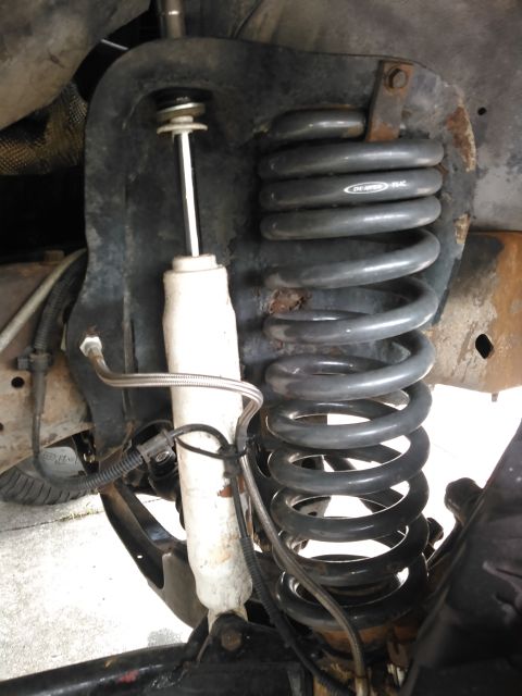 1996 Ford Bronco - Close-up of a front suspension shock and coil spring assembly, an Eibach branded coil spring.