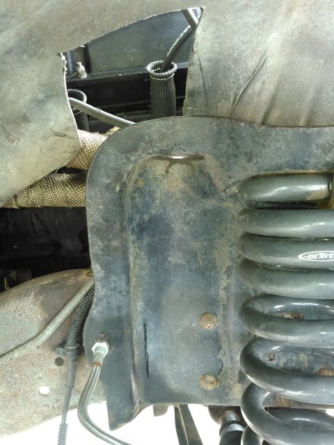 1996 Ford Bronco - This image shows a close-up view of a vehicle's suspension system, focusing on the coil spring and shock tower.