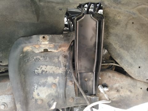 1996 Ford Bronco - A close-up view of the driver's side front wheel well area of a 1996 Ford Bronco, showing the shock absorber mount and surrounding frame co…