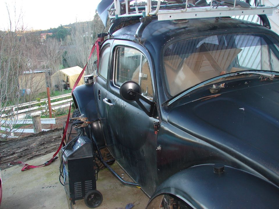 Black Volkswagen Beetle with a red strap and welding machine.