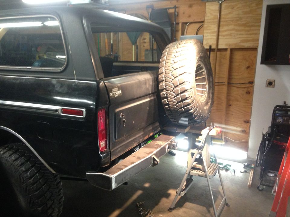 Black Ford Bronco rear with custom bumper and spare tire mount in a garage.