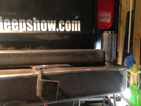 1979 Ford Bronco - A close-up view of a custom steel bumper being fabricated and attached to the rear of a vehicle. White lettering on the vehicle's body read…