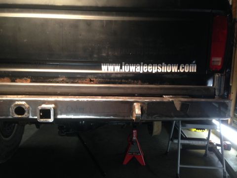 1979 Ford Bronco - The rear of a black Ford Bronco is shown with a custom-built steel bumper. The bumper features a receiver hitch and a circular trailer plug…