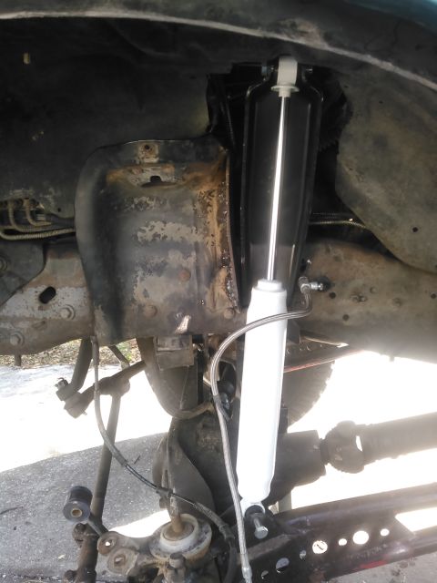 1996 Ford Bronco - A new black and white shock absorber has been installed on the driver's side rear suspension of a vehicle, likely a Ford Bronco, with visib…