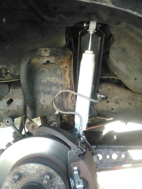 1996 Ford Bronco - This is a close-up view of the front suspension and braking system of a 1996 Ford Bronco. A new white shock absorber has been installed, an…
