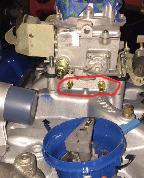 1978 Ford Bronco - A close-up view of a carburetor mounted on a V8 engine. Two brass fittings are circled in red on the side of the carburetor base.