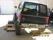 1985 Ford Bronco II - Rear view of a black 1985 Ford Bronco II, lifted and positioned on ramps.