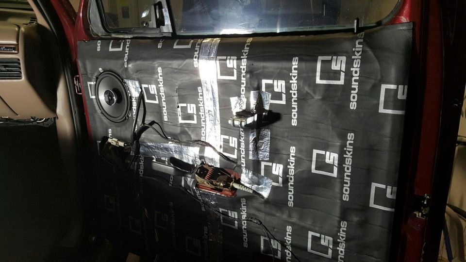 Vehicle door interior with sound deadening material and speaker.
