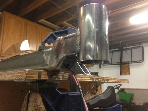 1979 Ford Bronco - A close-up view of a custom metal fabrication project, likely part of a vehicle build, featuring a large cylindrical tube welded to a struc…