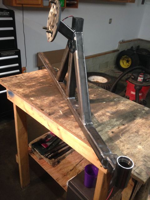 1979 Ford Bronco - A custom-fabricated steel trailer hitch assembly is shown mounted on a wooden workbench. The assembly features a wheel hub with studs and a…