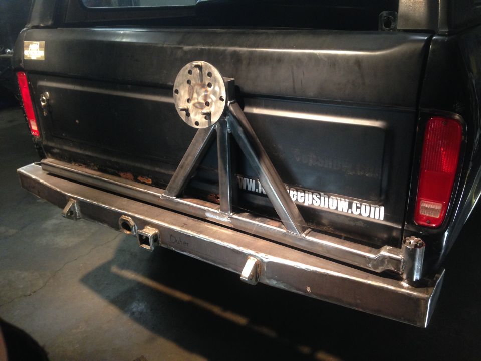 Rear view of a black 1979 Ford Bronco with a custom bumper and spare tire mount.