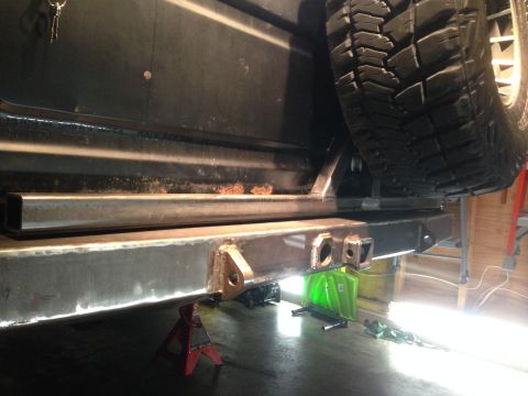 1979 Ford Bronco - A custom fabricated rear bumper with a receiver hitch is shown being installed on the rear of a dark-colored SUV, likely a Ford Bronco, wit…