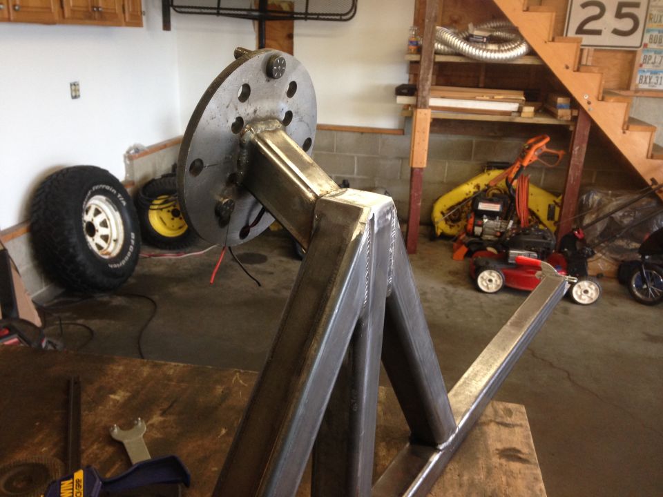 Custom steel stand with wheel hub in garage with tires and lawn equipment
