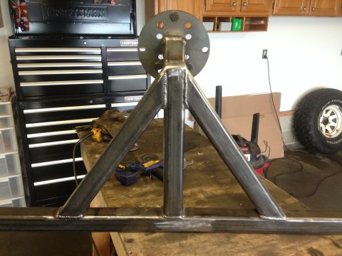 1979 Ford Bronco - A custom fabricated steel tire carrier mount is shown in a workshop setting. The mount is welded and appears to be ready for installation.