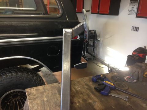 1979 Ford Bronco - A close-up view of the rear driver's side of a black SUV, likely a Ford Bronco, showing a custom metal fabrication project in progress. A m…