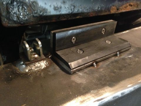 1979 Ford Bronco - A close-up view shows a custom metal bracket with two screws attached to a larger metal surface. To the left, a U-shaped metal bracket is w…