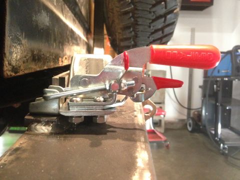 1979 Ford Bronco - A close-up view of a metal toggle clamp with a red handle is attached to the frame of a vehicle. The clamp is securing a piece of metal to…