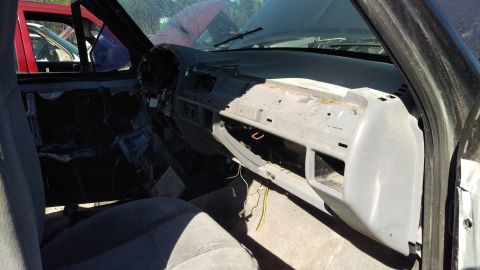 1994 Ford Bronco - The interior of a vehicle, likely a truck or SUV, shows a disassembled dashboard with exposed wiring and a removed glove box. The seats and…