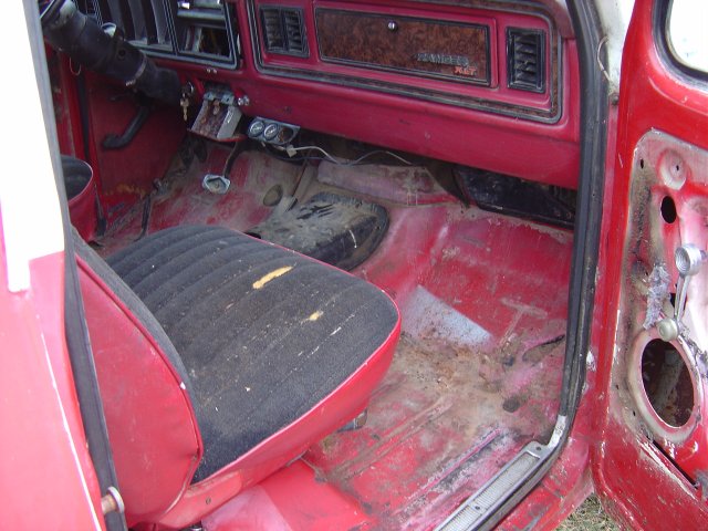 Interior of a 1979 Ford Bronco showing the driver's seat, dashboard, and floor