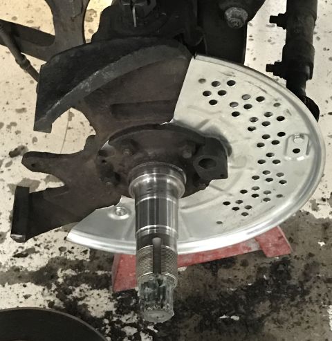 1995 Ford Bronco - Front wheel hub assembly with brake rotor dust shield, likely during a brake job.