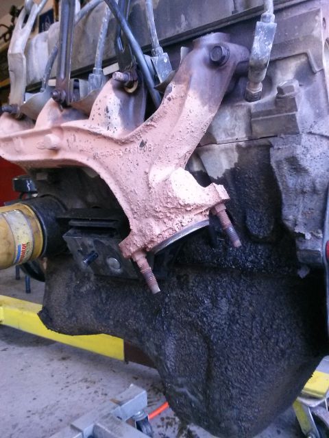 1996 Ford Bronco - Close-up view of an engine block with an exhaust manifold, likely during a repair or re-seal process.