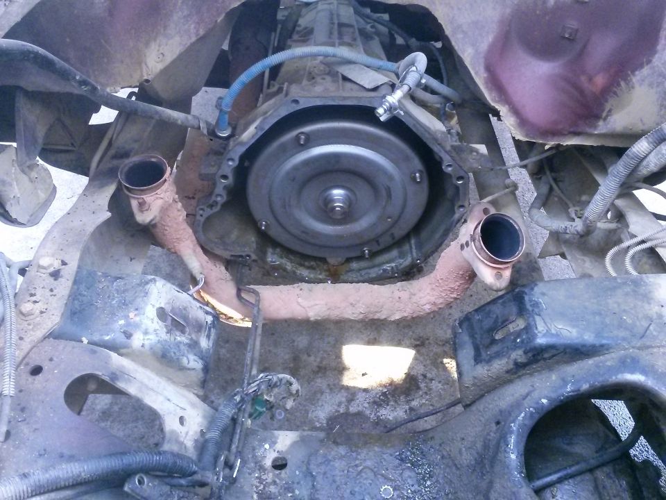 vehicle transmission and exhaust pipes removed for repair