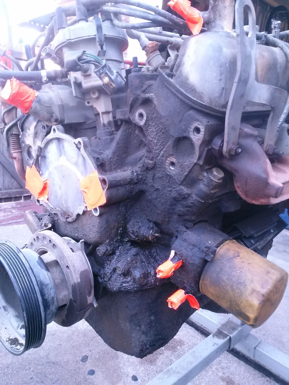 Engine block with orange tape on ports and oil filter attached