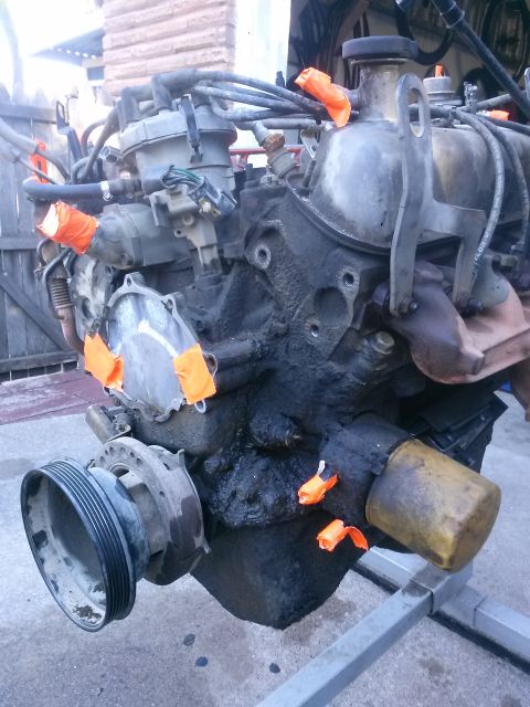 1996 Ford Bronco - Engine block assembly with various components attached and orange tape on openings.