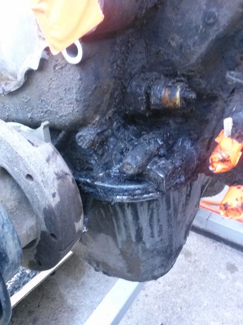 1996 Ford Bronco - The engine's oil pan is covered in thick, black grime and appears to be leaking oil-or has recently been-leaking oil.