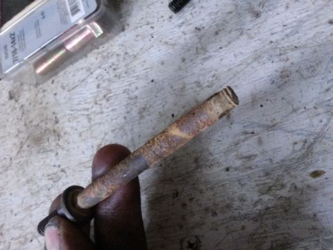 1996 Ford Bronco - A close-up of a rusted bolt being held, with a package of new bolts visible.