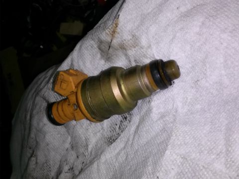1996 Ford Bronco - A single fuel injector, likely for a Ford vehicle, is shown on a white cloth.