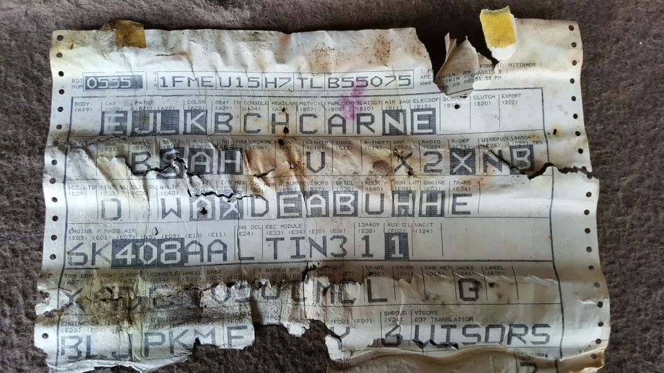 Damaged Ford build sheet with body, paint, trim and option codes on tractor-feed paper