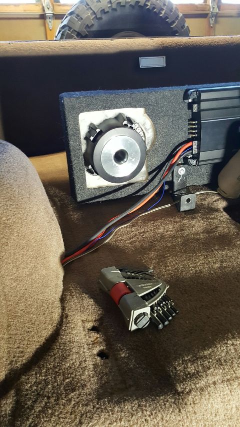 1996 Ford Bronco - Interior view of a vehicle showing a speaker, amplifier, and tools, with a spare tire in the background.