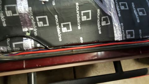 1996 Ford Bronco - Sound deadening material with brand logo is installed over wiring and insulation.