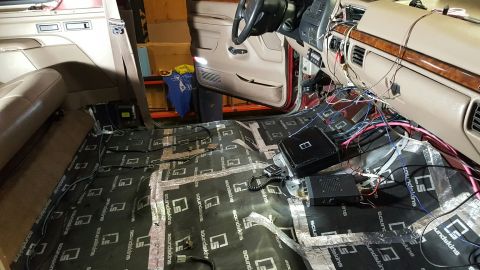 1996 Ford Bronco - Sound deadening material and wiring are laid out on the floor of a vehicle's interior during an installation.