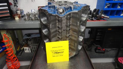 1982 Ford Bronco - A Ford 427W engine block sits on a workbench with a yellow tag detailing its rebuild.